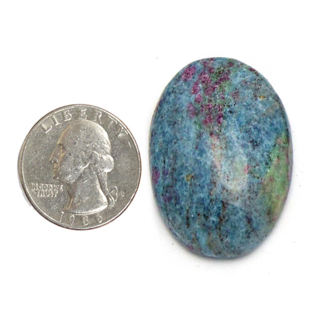 ruby fuchsite worry stone next to a quarter for size reference on white background